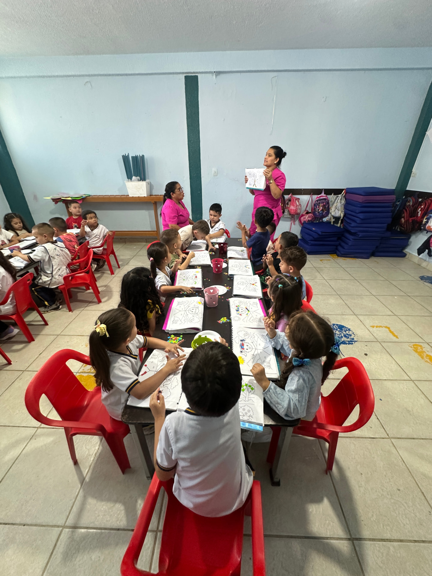 Profesoras del Hogar Infantil Pilatunas acompañando una actividad de dibujo con niñas y niños