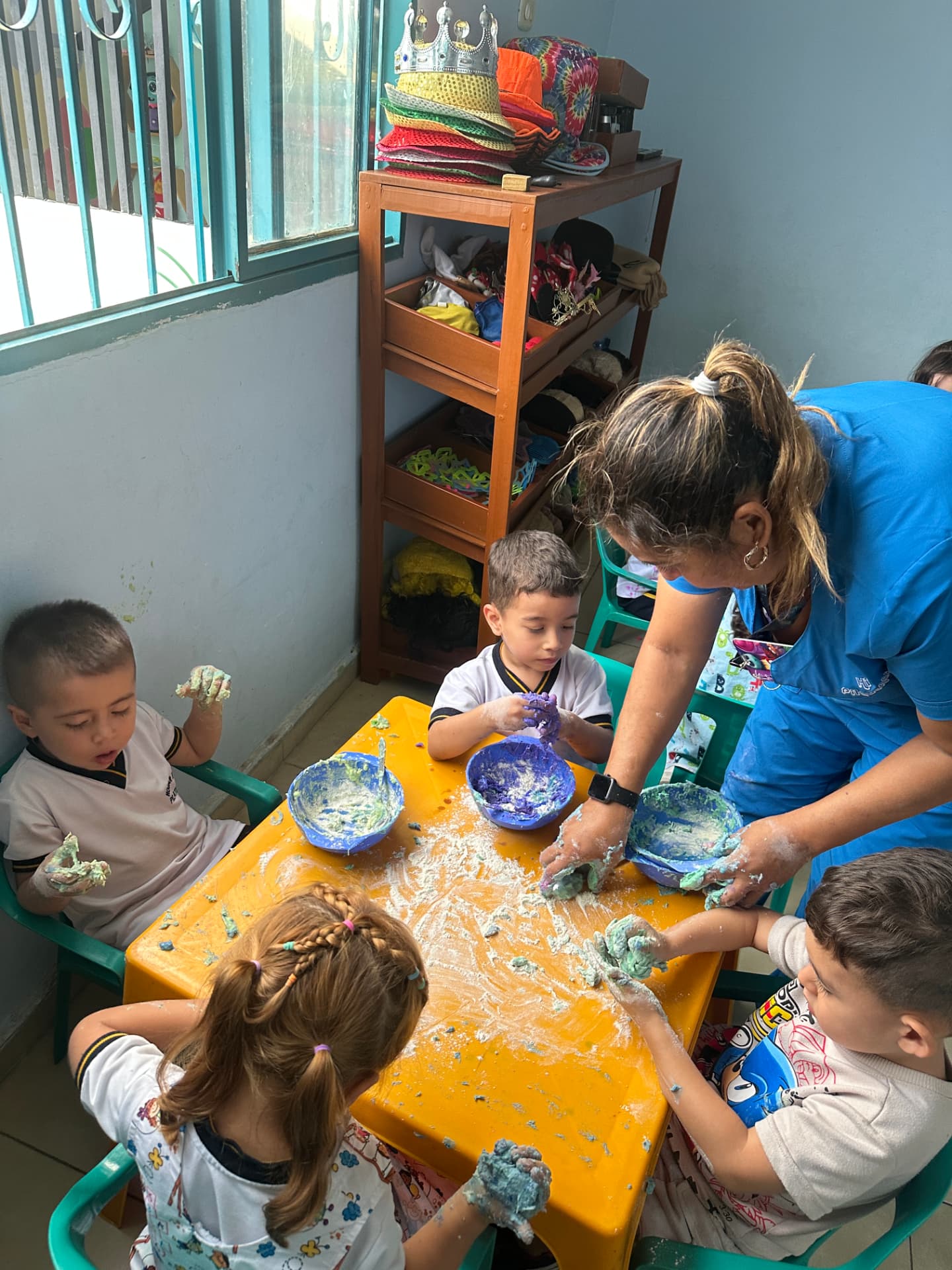 Niñas y niños explorando con masa sensorial junto a una docente