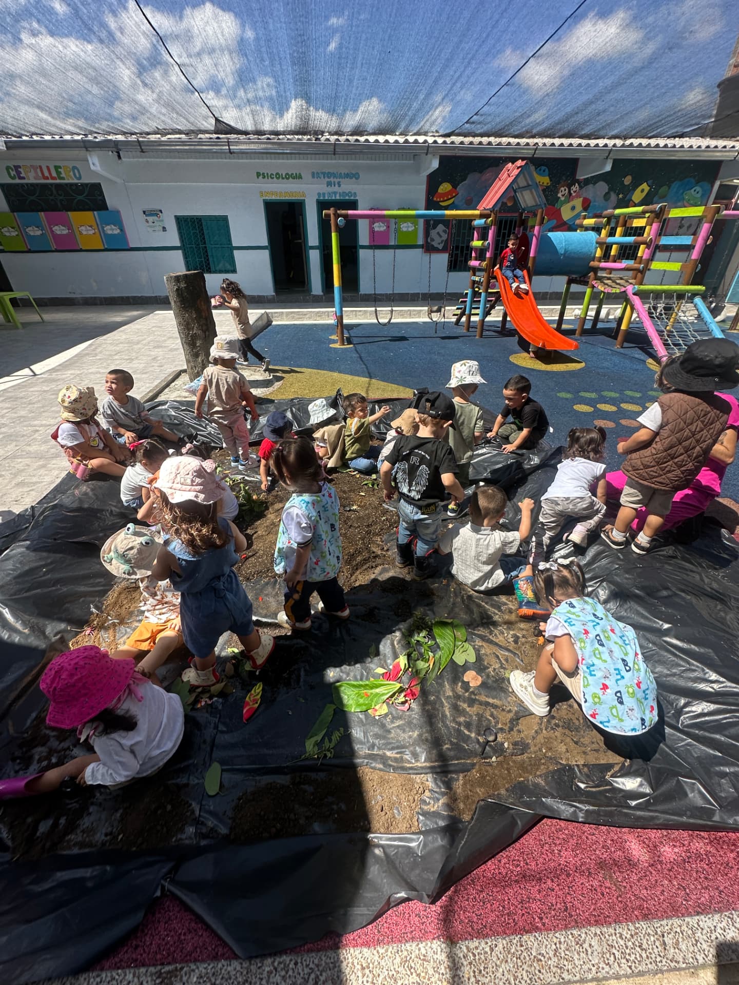 Niñas y niños explorando y jugando en el patio del Hogar Infantil Pilatunas